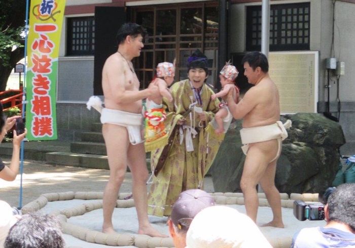 力士に抱っこされて土俵の上へ。伝統行事「泣き相撲」