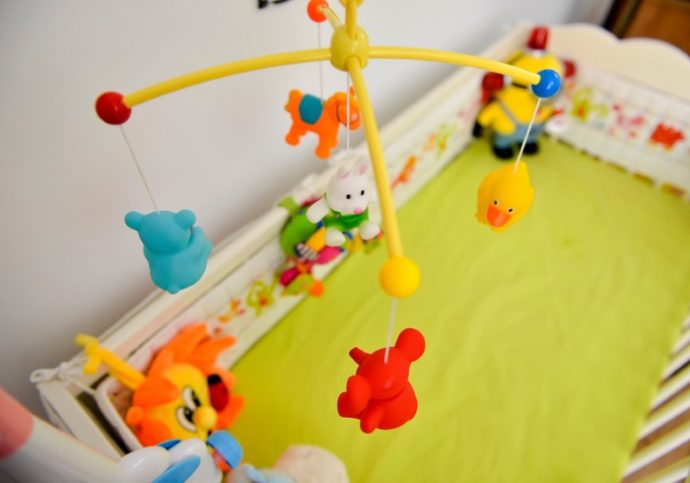 Baby cot with colorful toys hanging