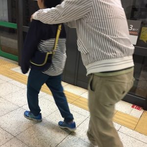 肉離れ中の父に肩を貸す息子。