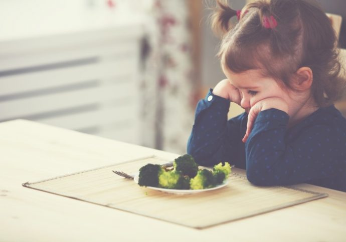 child girl does not like and does not want to eat vegetables