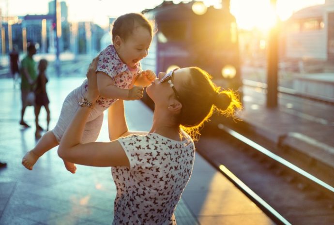 Pretty mom carrying her little daughter
