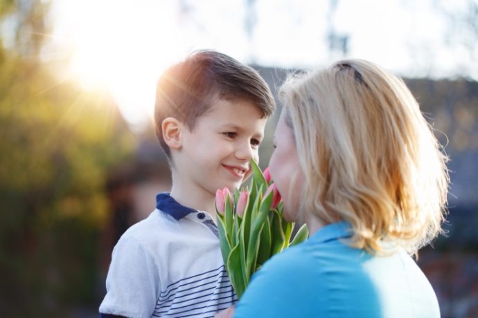 Little boy surprising mom with tulips at Mother’s Day