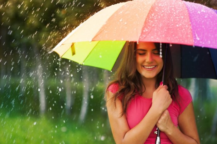 Beautiful woman under rainbow umbrella