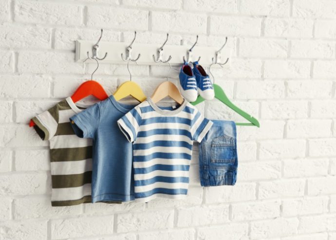 Set of baby clothes on brick wall background