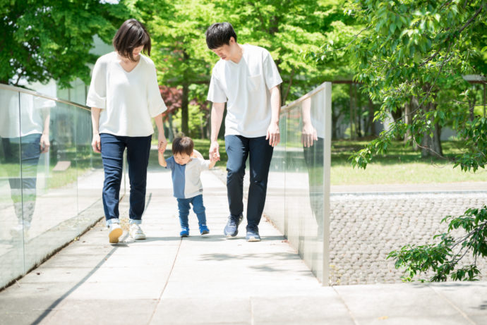 手を繋いで歩く家族