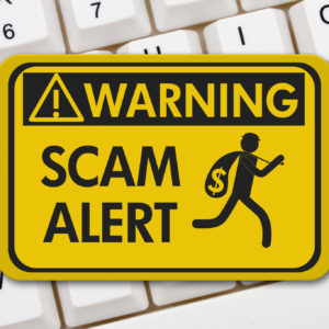 Scam alert warning sign, A yellow warning sign with text Scam Alert and theft icon on a keyboard