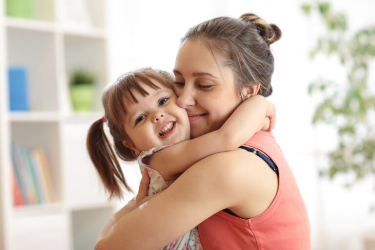 love and family concept - happy mother and child daughter hugging at home