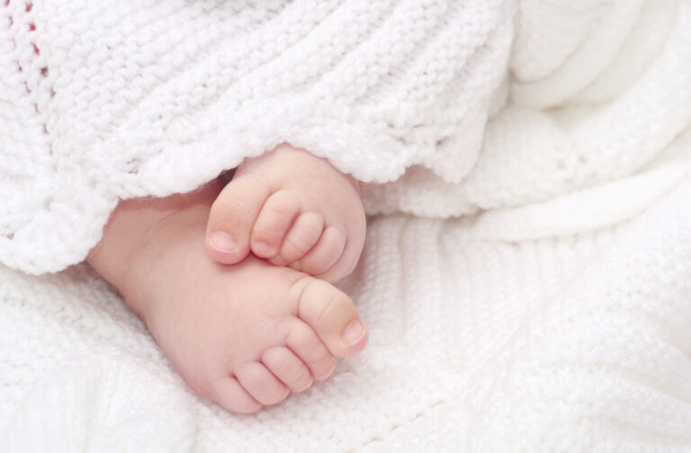 Close up of adorable baby feet on blanket